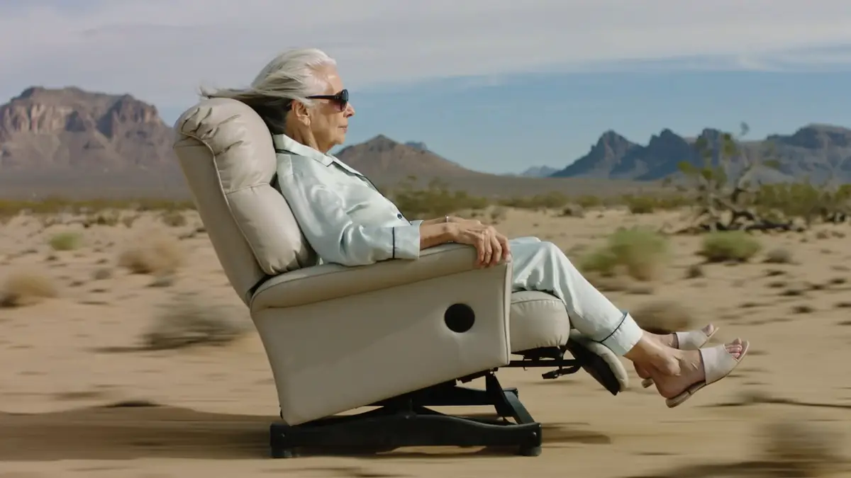 Woman riding a recliner through the desert preview
