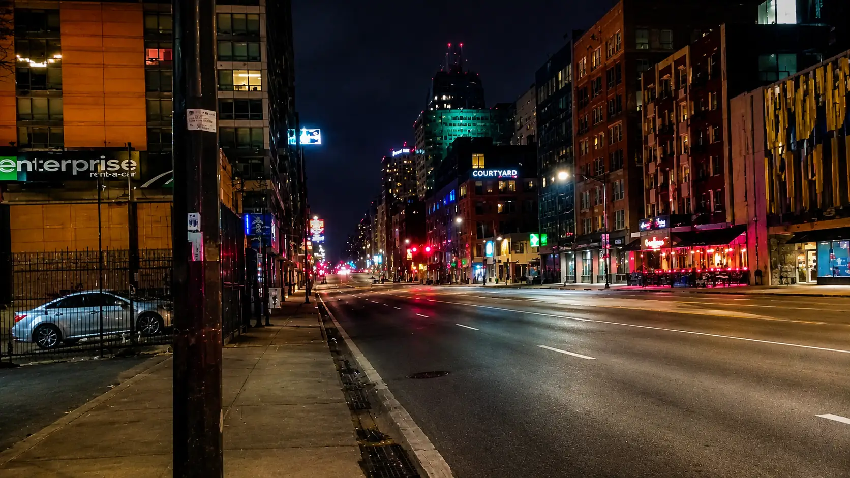 Before-and-after slider for a noisy low-light city street cleaned for better contrast and detail. result