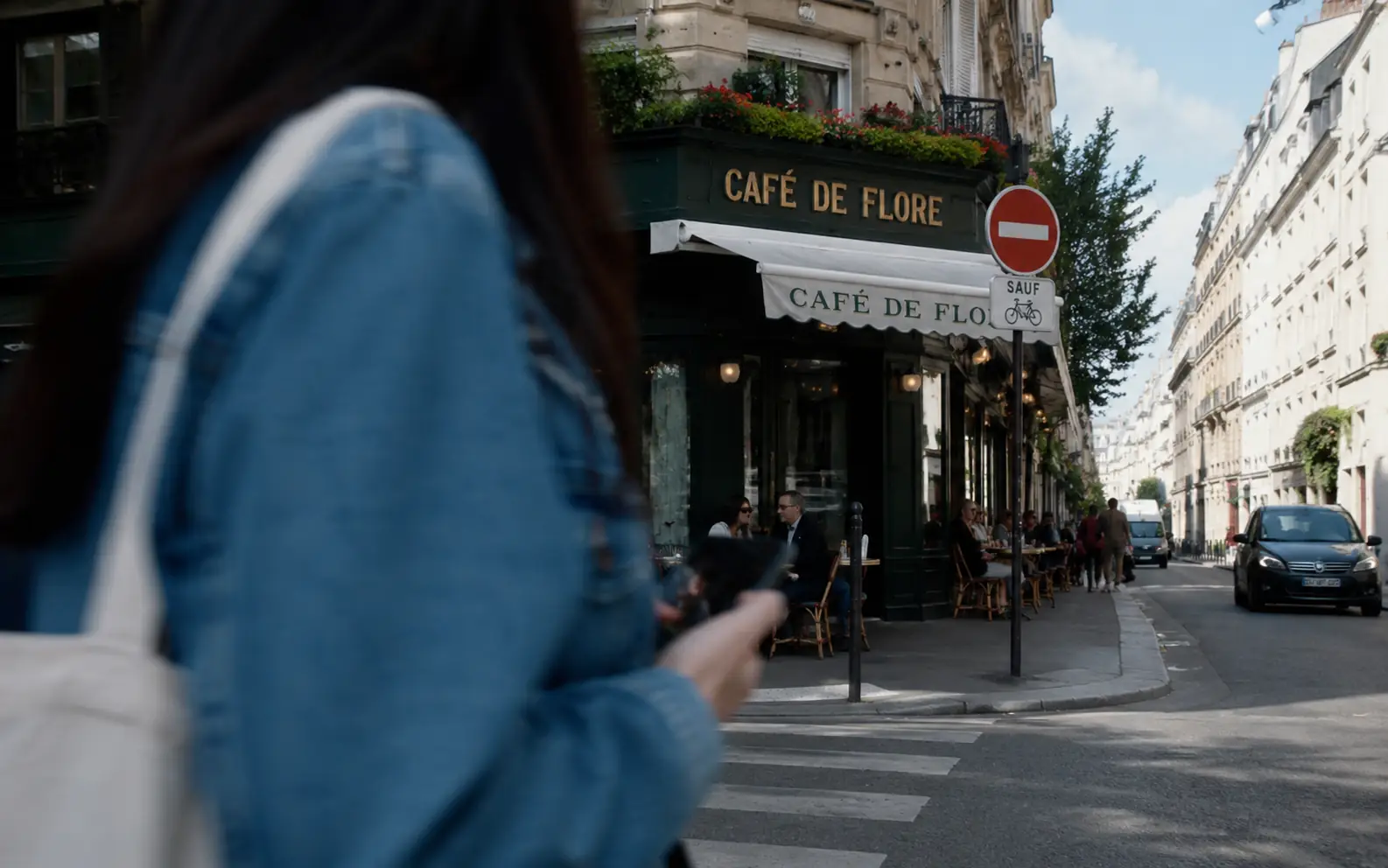 Before-and-after comparison of a foreground person removed from a Paris cafe street photo.