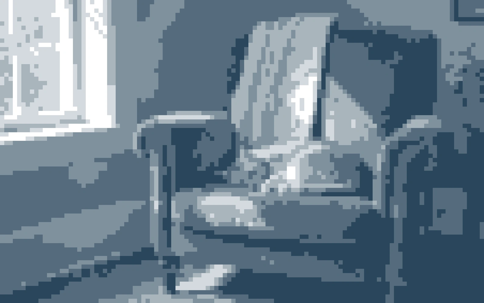 An orange cat asleep on a green armchair compared with the same scene rendered as six blue-gray value blocks.