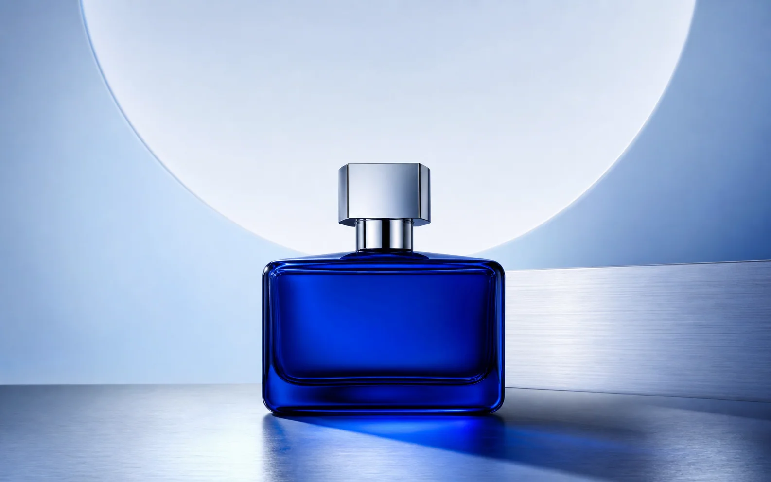 Cobalt-blue perfume bottle in a polished silver campaign setting.