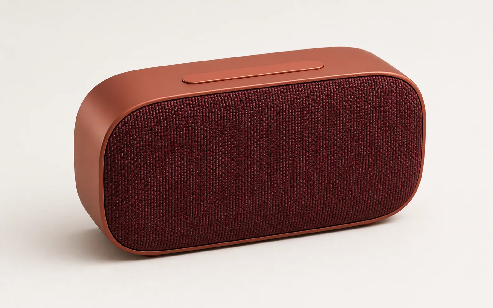 Terracotta portable speaker shown clearly against a neutral studio background.