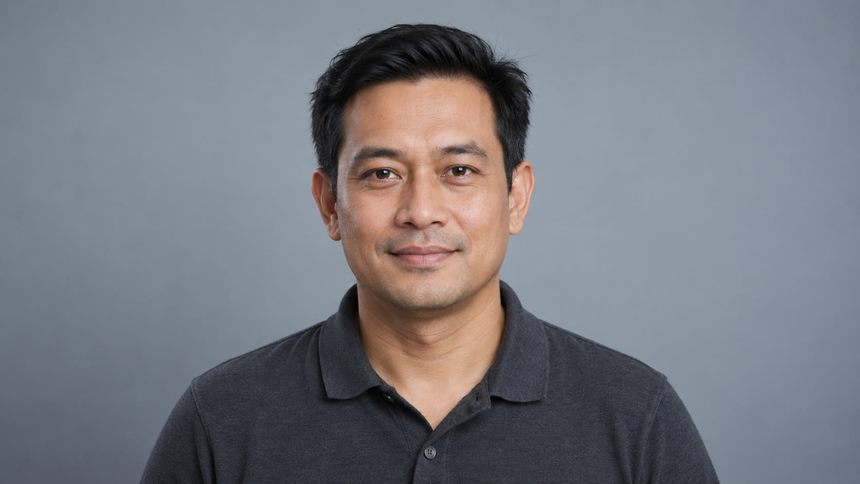 Man with short dark hair in a charcoal polo shirt
