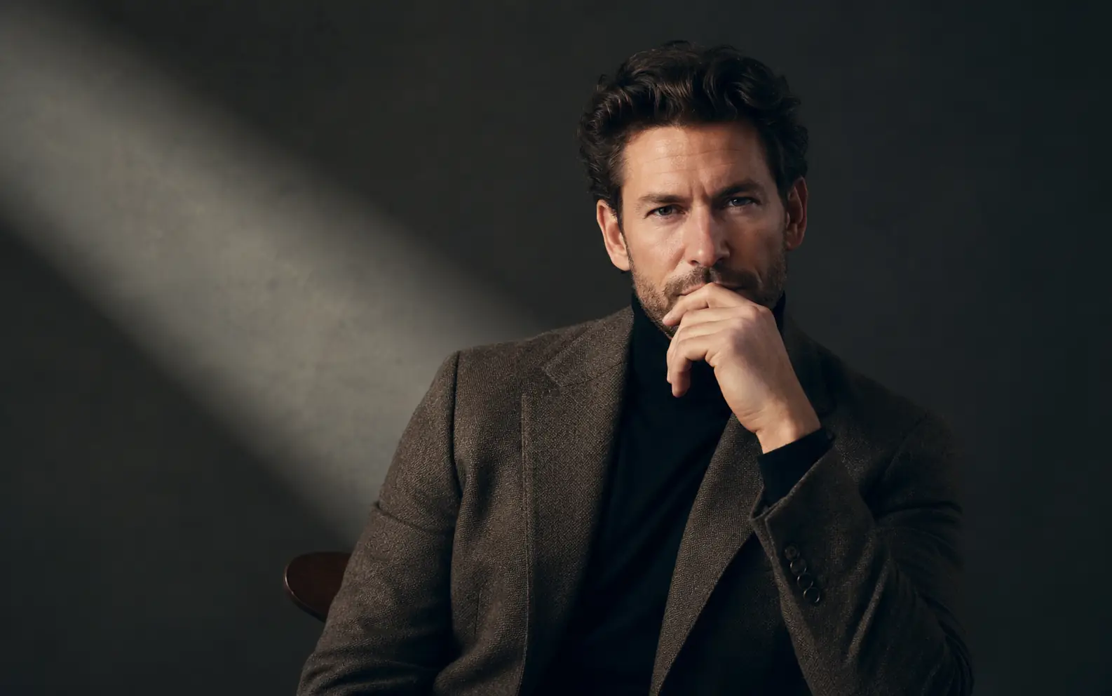 Text to image portrait of a man in moody editorial lighting.