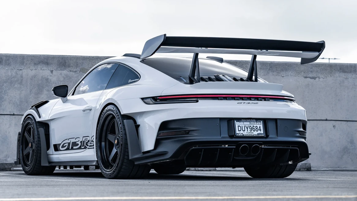 Before-and-after slider for a blurred sports car restored for clearer body lines, wheels, and rear spoiler detail.