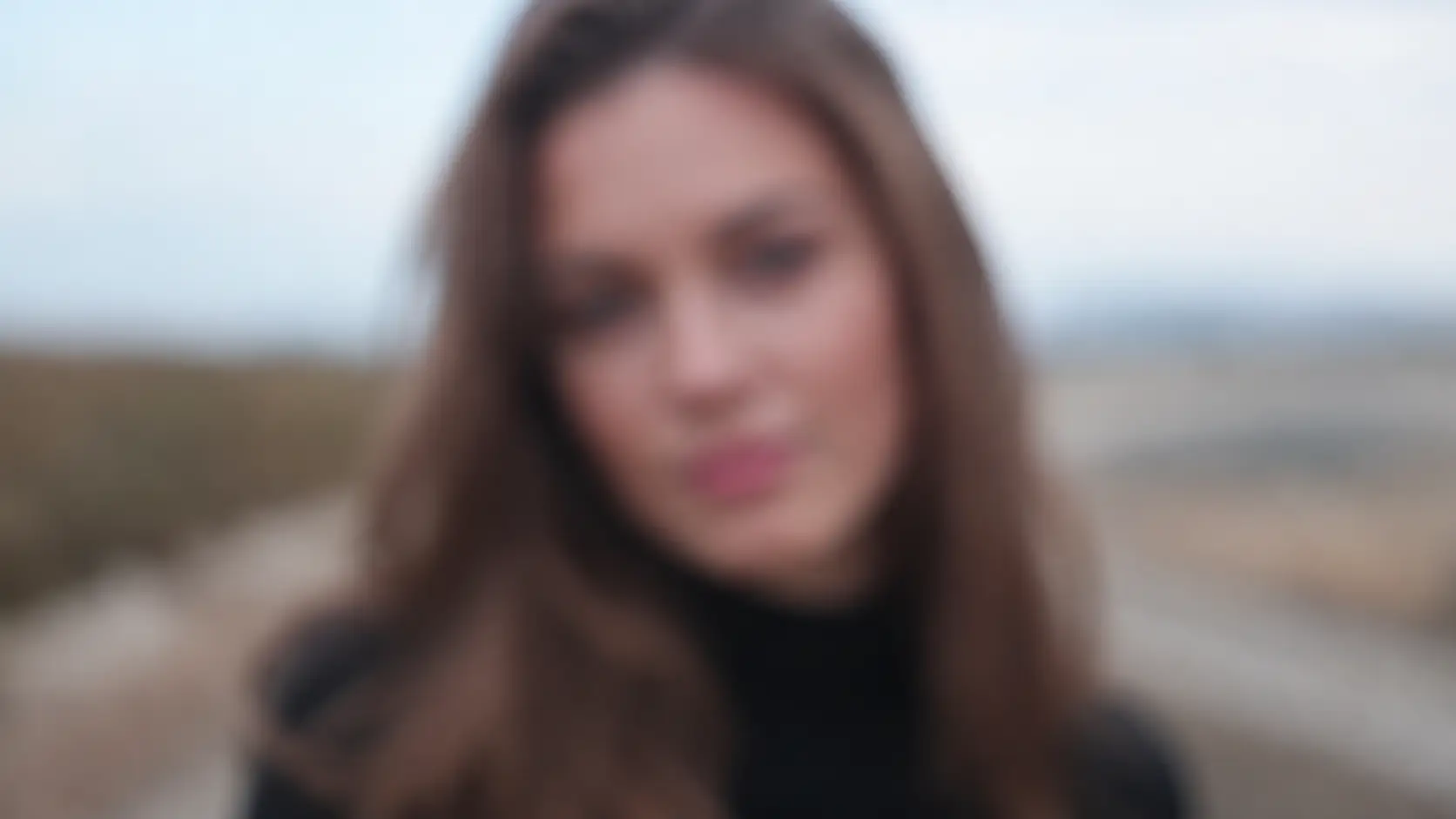 Before-and-after slider for a blurred outdoor portrait restored for clearer facial detail.